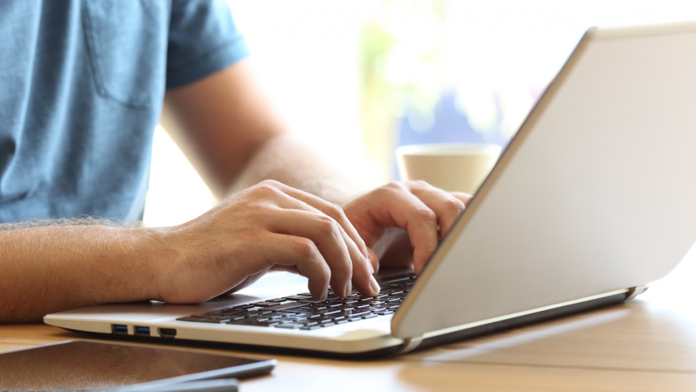 Hands typing on a laptop