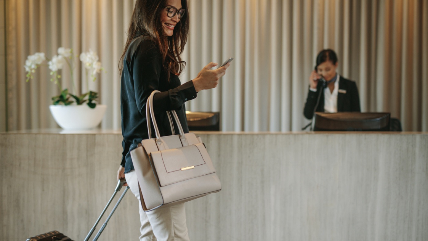 Woman using phone in hotel lobby