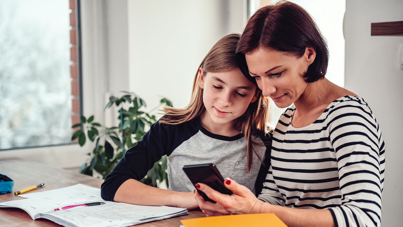 mom and daughter looking at a cell phone