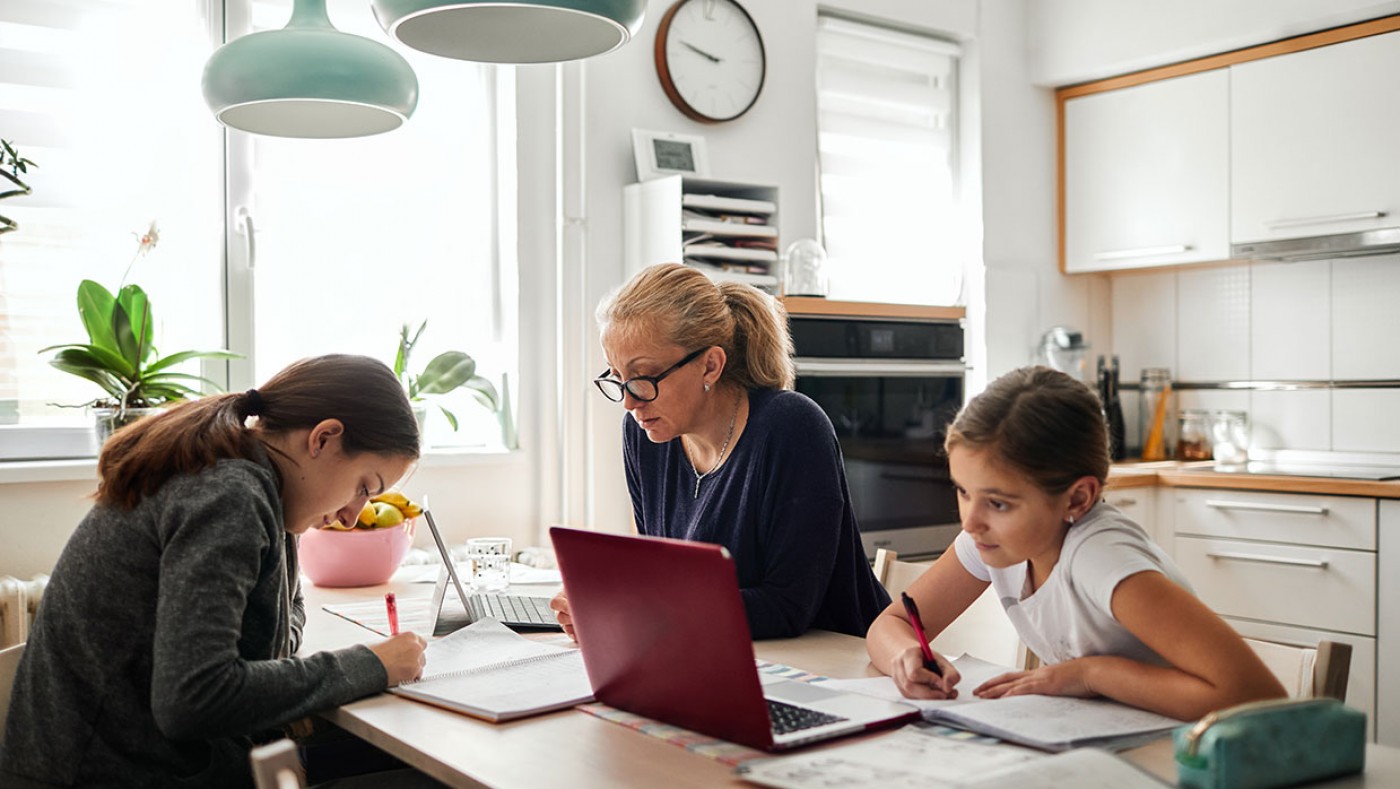 family using laptops at the kitchen counter