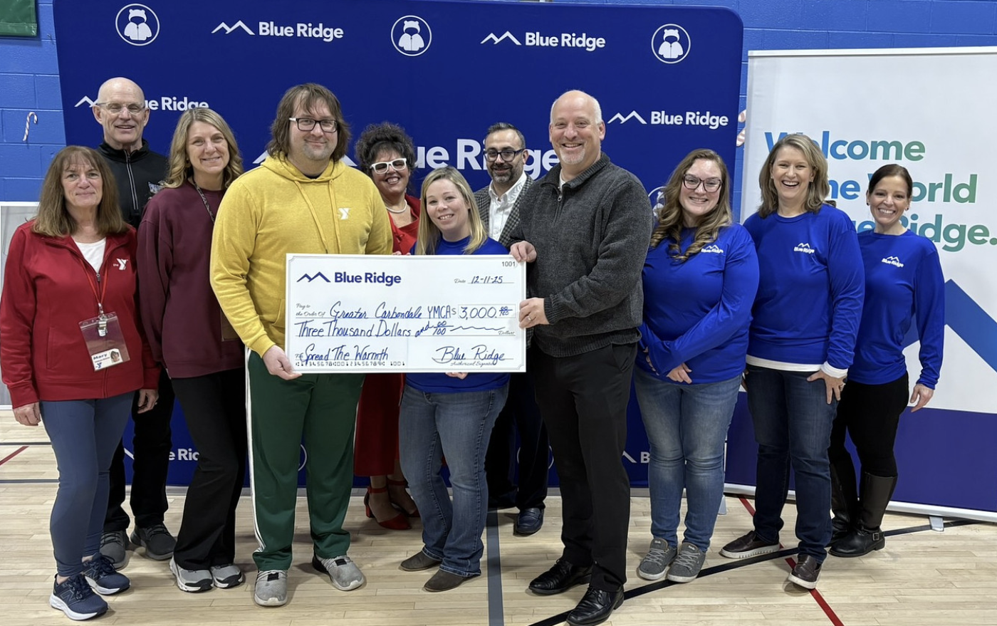 Blue Ridge employees holding check donation in front off STW banner
