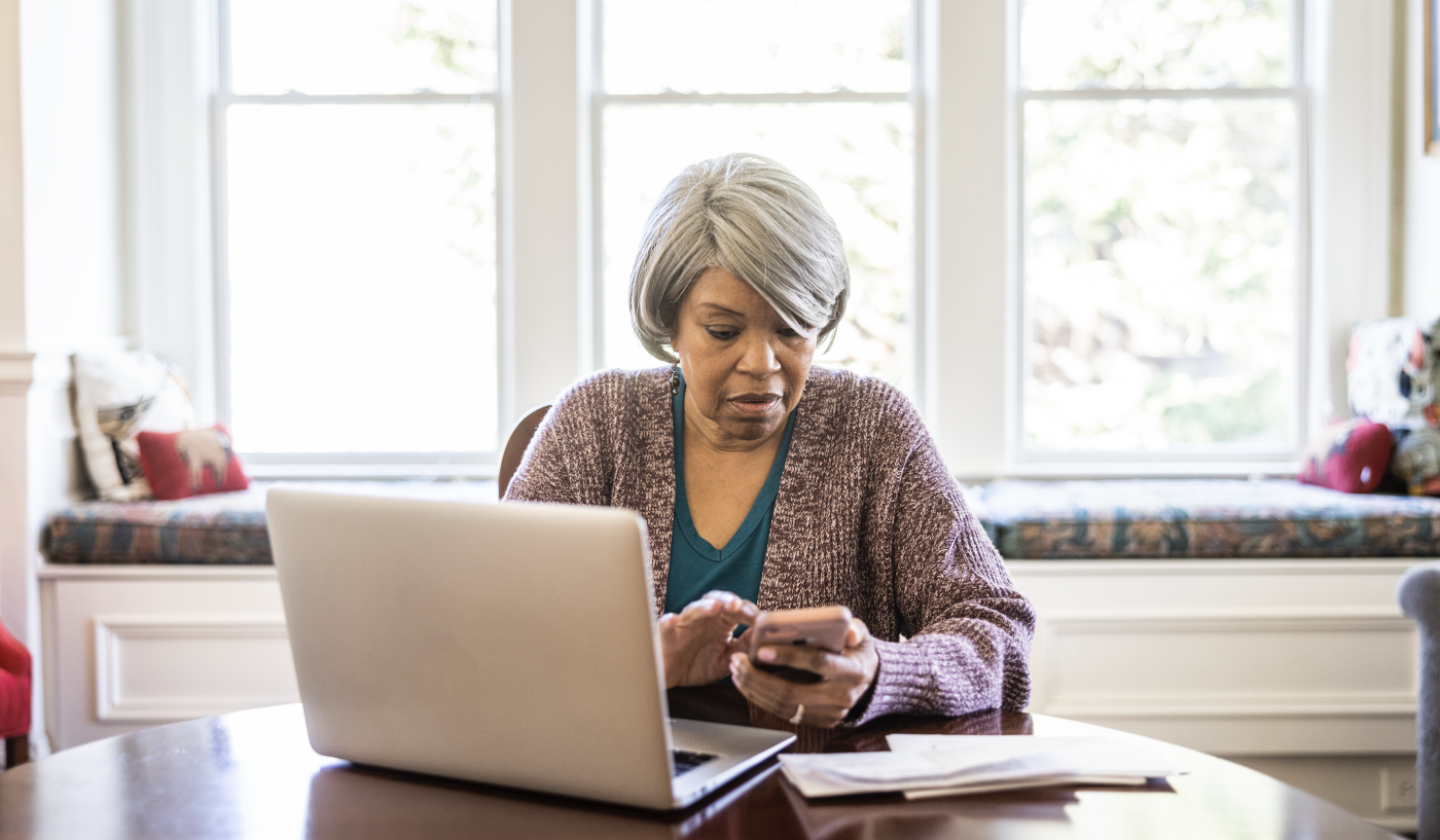 older woman looking at online bills at home